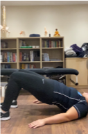 A person sitting next to a book shelf  Description automatically generated